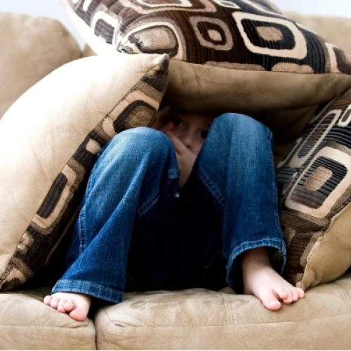 Child hiding in couch cushions